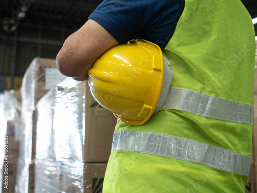 yellow orange color hardhat safety helmet holding arm hand person labor people human copy space equipment construction work job protection building engineer shipping custom import export dangerous photo