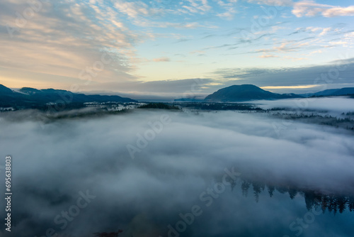 Valley by Lake  Mountains and Green Trees covered in fog. Canadian Landscape Nature Aerial Background