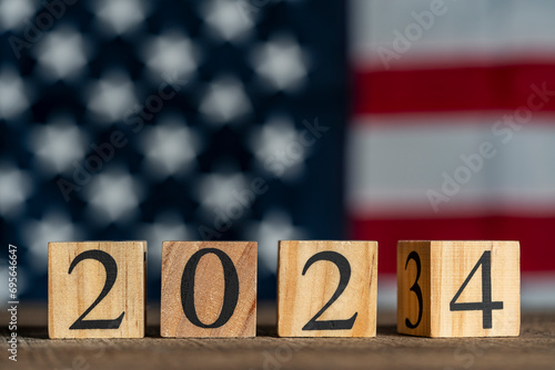 Starting new year 2024. Flipping of 2023 to 2024 on wooden cube blocks against the backdrop of the American flag. Inspiration to success ideas