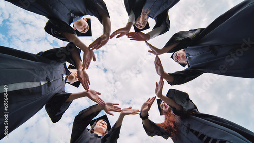 College graduates make a circle of their hands. photo