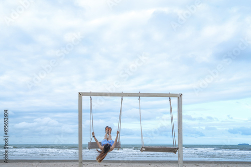 Portrait beautiful young asian woman relax smile leisure on swing around beach sea ocean with blue sky white cloud