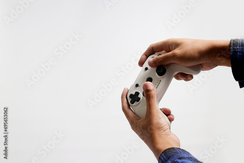 Hand holding a gamepad or joystick against a white background with empty copy space for text or advertisement photo
