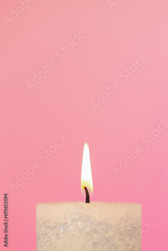 Burning candle .Candle flame.White candle close-up on a pink background.Beautiful background with a candle in pastel colors
