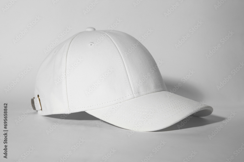 Stylish white baseball cap on light background Stylish white baseball cap on light background