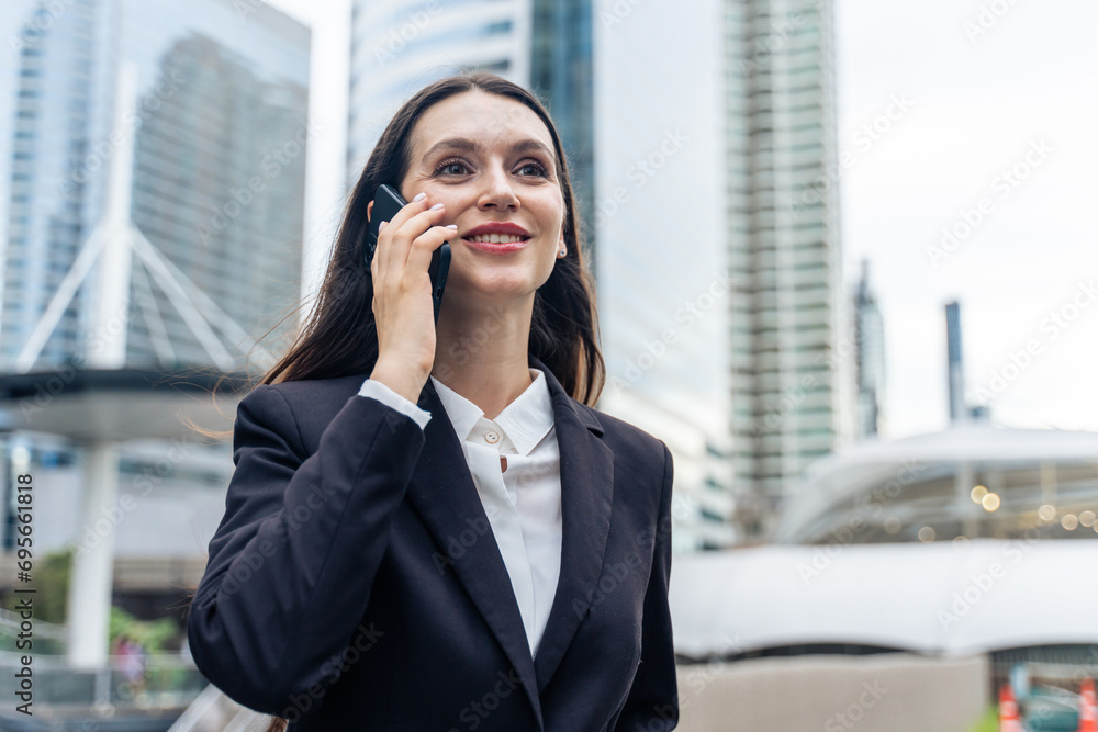 Caucasian young businesswoman talking on smartphone while walk in city. Caucasian young businesswoman talking on smartphone while walk in city.