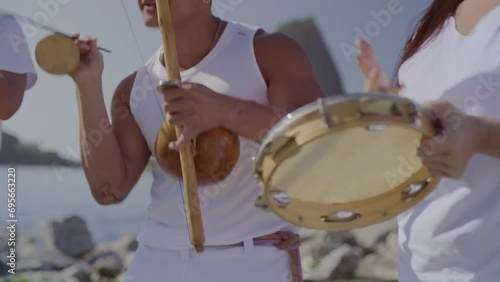 Jovens tocando instrumentos musicais típicos brasileiros. Jogando capoeira, arte marcial afro-brasileira, no Rio de Janeiro. Cinematico 4k. photo