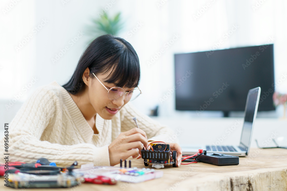 Woman assemble a robot and coding. Woman assemble a robot and coding.