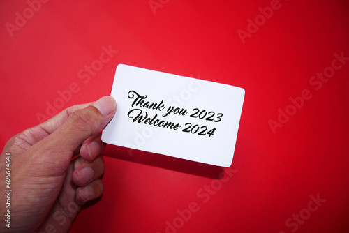 A piece of paper in a man's hand with the words BYE BYE 2023. Goodbye 2023, welcome 2024. Thank you 2023.