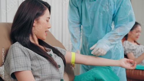 Doctor fumble blood vessel on arm of blood donor asian woman preparing steps during venipuncture to donation at hospital photo