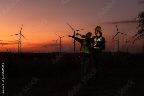 Engineers working on wind turbines farm at sunset, Wind turbines are alternative energy source. photo