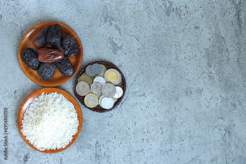 Dates fruit, coins and rice grain in wooden bowls on grey background, top view. Eid mubarak concept