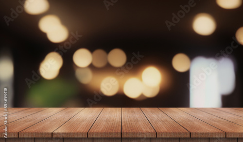 Empty wooden table top with lights bokeh on blur restaurant background.