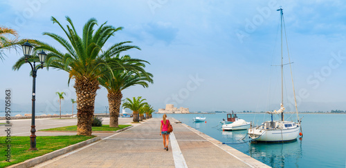 Nafplio city in Greece with palm trees, boats and bourtzi castle in mediterranean sea photo