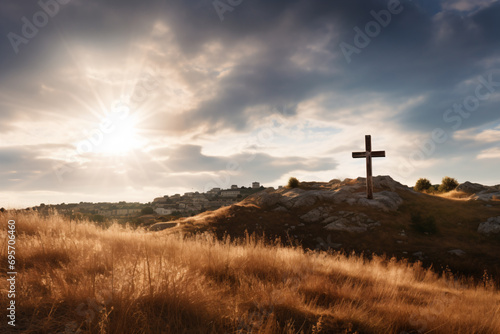 a cross on a hill with a sun in the background