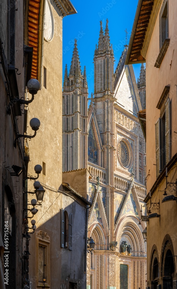 vertical view of narrow Orvieto Streets with the spire of the Orvieto Cathedral behind