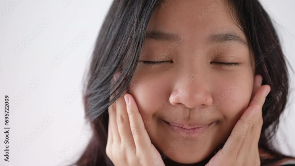 A cute Asian girl looks at the camera and her eyes wink