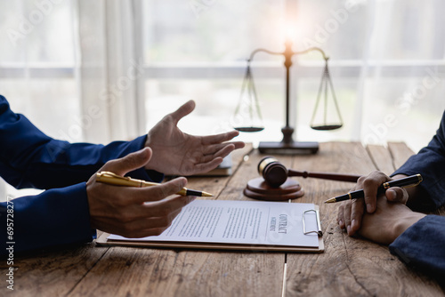 Lawyer holds a pen and provides consulting services in business disputes with a scale and hammer. In the event that the customer is defrauded Close-up pictures