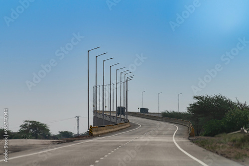 Flyover on the road connecting Jaisalmer and Jodhpur, Rajasthan, India. National Highway 68, NH 68. Bly sky above. photo