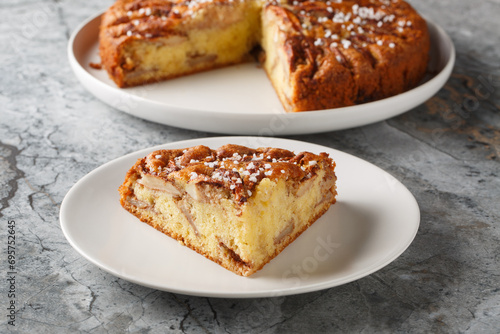 Eplekake traditional Norwegian apple cake or pie sprinkled sugar on a plate close-up on the table. Horizontal photo