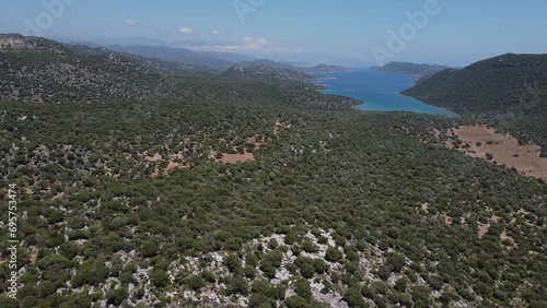 Typical Mediterranean coastal mountains sprawling with green shrubs out to stunning blue sea photo