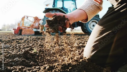 Male hands full of fertile soil, land field agriculture concept. Handful of dirt holding dark soil from organic field. Human hands holding ecologically controlled re-constituted soil. photo