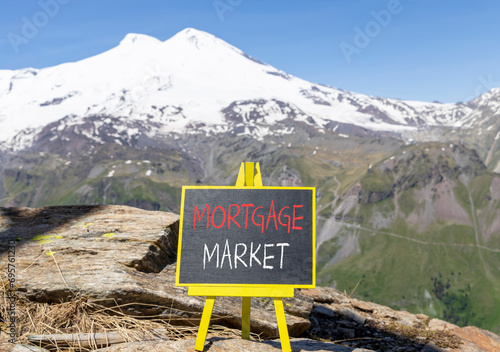 Mortgage market symbol. Concept words Mortgage market on beautiful black chalk blackboard. Beautiful mountain Elbrus blue sky background. Business mortgage market concept. Copy space. © Dzmitry