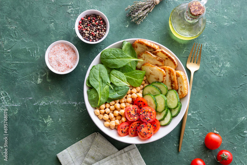 Bowl with grilled Halloumi cheese, spinach, chickpeas, tomatoes and cucumbers. Healthy eating. Vegetarian food. Diet. photo