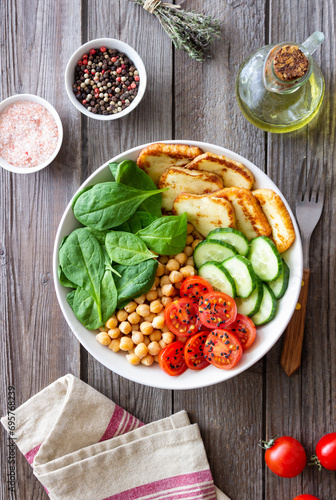 Bowl with grilled Halloumi cheese  spinach  chickpeas  tomatoes and cucumbers. Healthy eating. Vegetarian food. Diet.