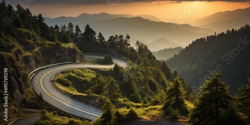 A winding road through a forested mountain area at sunset. photo