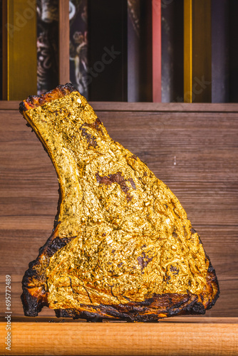 Bistecca di carne cotta alla brace e decorata con fogli d'oro edibili photo