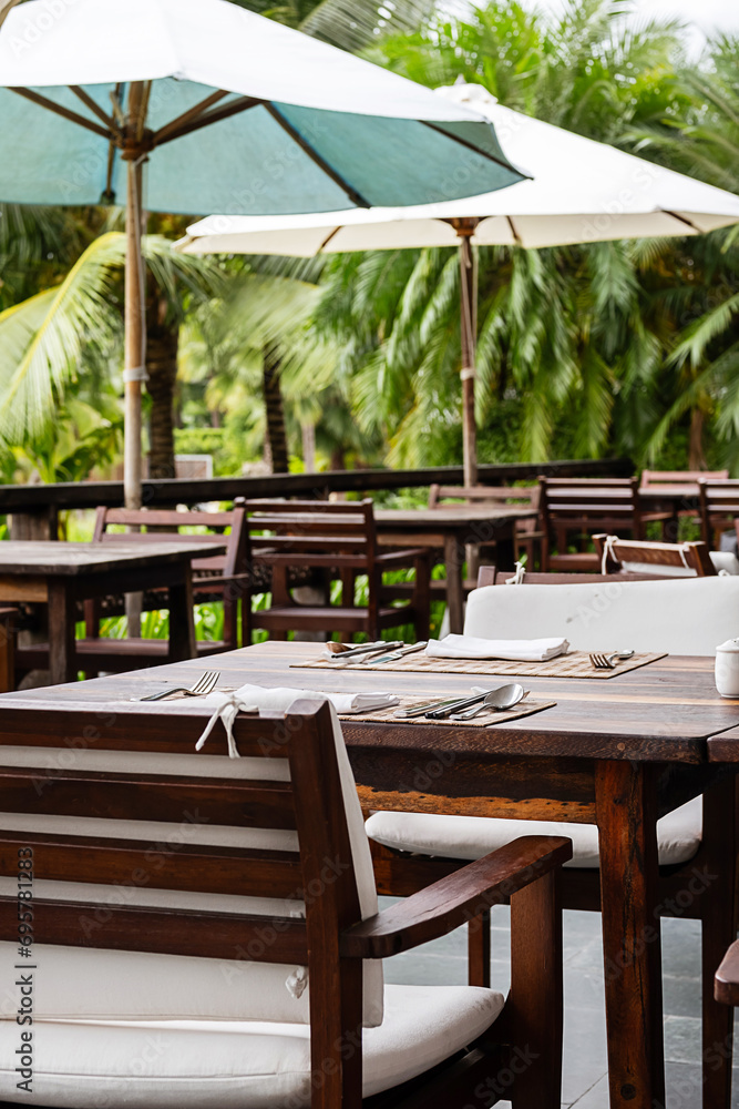 Outdoor restaurant surround palm trees.