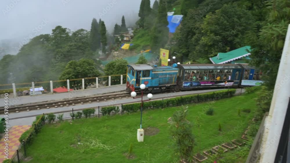 Darjeeling,West Bengal,India- 20.08.2023 : Famous Diesel Toy train passing through Batasia loop, memorial to the Gorkha soldiers of the Indian Army. Darjeeling Himalayan Railway, narrow gauge railway. Darjeeling,West Bengal,India- 20.08.2023 : Famous Diesel Toy train passing through Batasia loop, memorial to the Gorkha soldiers of the Indian Army. Darjeeling Himalayan Railway, narrow gauge railway.
