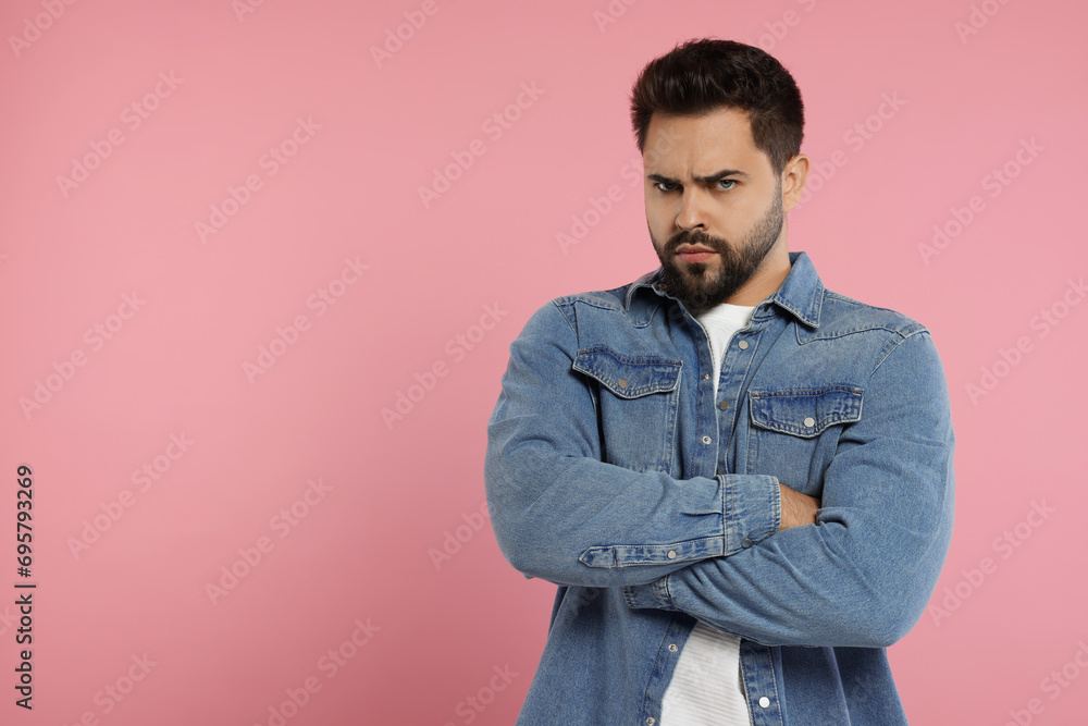 Portrait of resentful man with crossed arms on pink background, space for text Portrait of resentful man with crossed arms on pink background, space for text