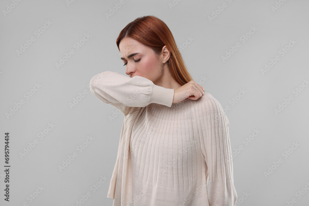Woman coughing on light grey background. Cold symptoms Woman coughing on light grey background. Cold symptoms