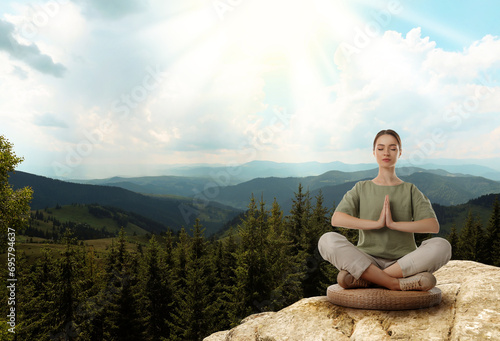 Woman meditating in mountains at sunrise, space for text