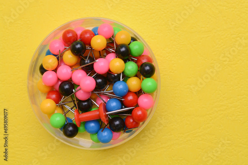 Colorful pushpins in the plastic box. pushpins are useful for affixing studies, bits of inspiration, or memos to a corkboard or wall. photo