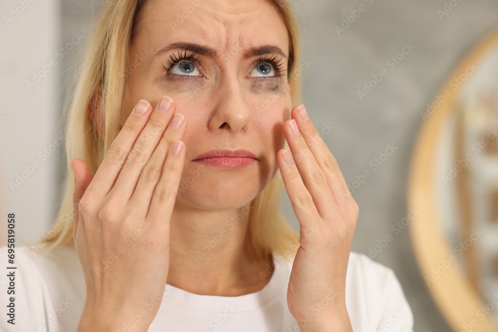 Sad woman with smeared mascara crying indoors, closeup Sad woman with smeared mascara crying indoors, closeup