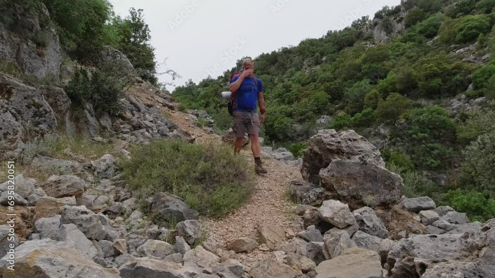 A solo male white hiker walks downhill on an easy path on the Lycian Way in Turkey A solo male white hiker walks downhill on an easy path on the Lycian Way in Turkey