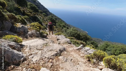 A young fit male hiker walking uphill on a steep climb along the Mediterranean Sea in Turkey