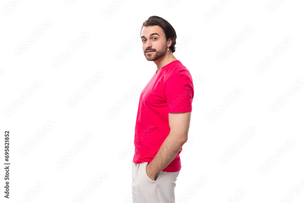 a young black-haired European man dressed in a red corporate T-shirt stands in profile a young black-haired European man dressed in a red corporate T-shirt stands in profile