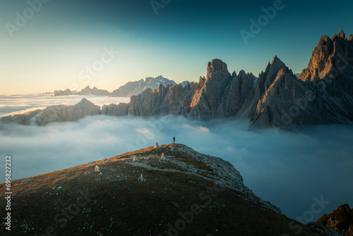 Majestic Sunrise Over Tre Cime Dolomites: Aerial View of Mountain Peaks in Tranquil Cloud Inversion photo
