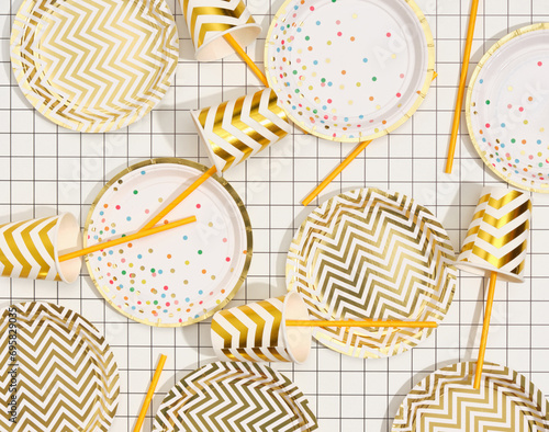 Image of stylish birthday beautiful table setting. Top view of plates, cups and straws.
