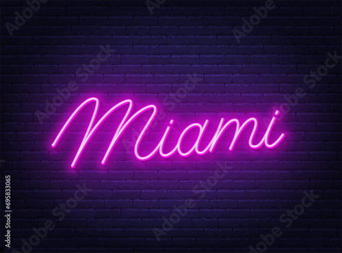 Miami neon lettering on brick wall background.