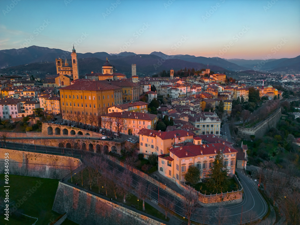 Beautiful sunset in Bergamo, Italy. Scenic aerial view of the old town city center Citta Alta. Landscape of the historical buildings during the sunset