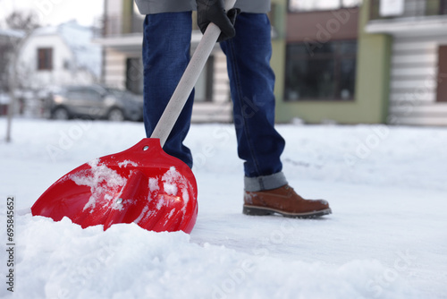 Man shoveling snow on city street, closeup