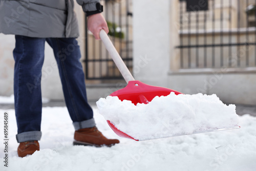 Man removing snow with shovel outdoors, closeup