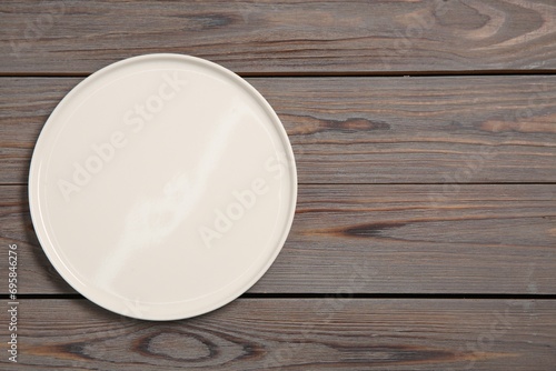 One ceramic plate on grey wooden table, top view. Space for text
