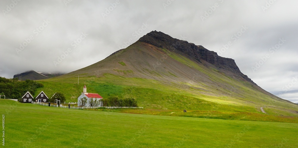 Grey and red church below the Icelandic volcano