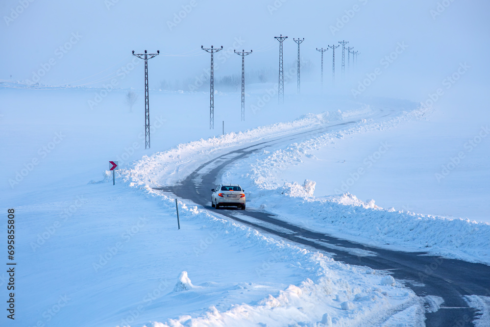 A road and electrical wires covered in snow A road and electrical wires covered in snow