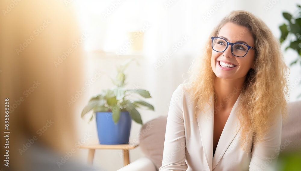 Smiling businesswoman with eyeglasses sitting on sofa at office Smiling businesswoman with eyeglasses sitting on sofa at office